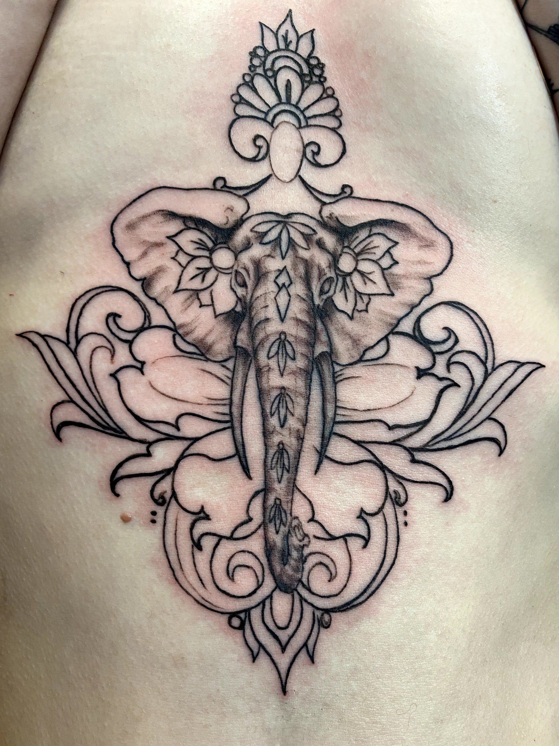 A tattoo of an elephant with a crown on its head