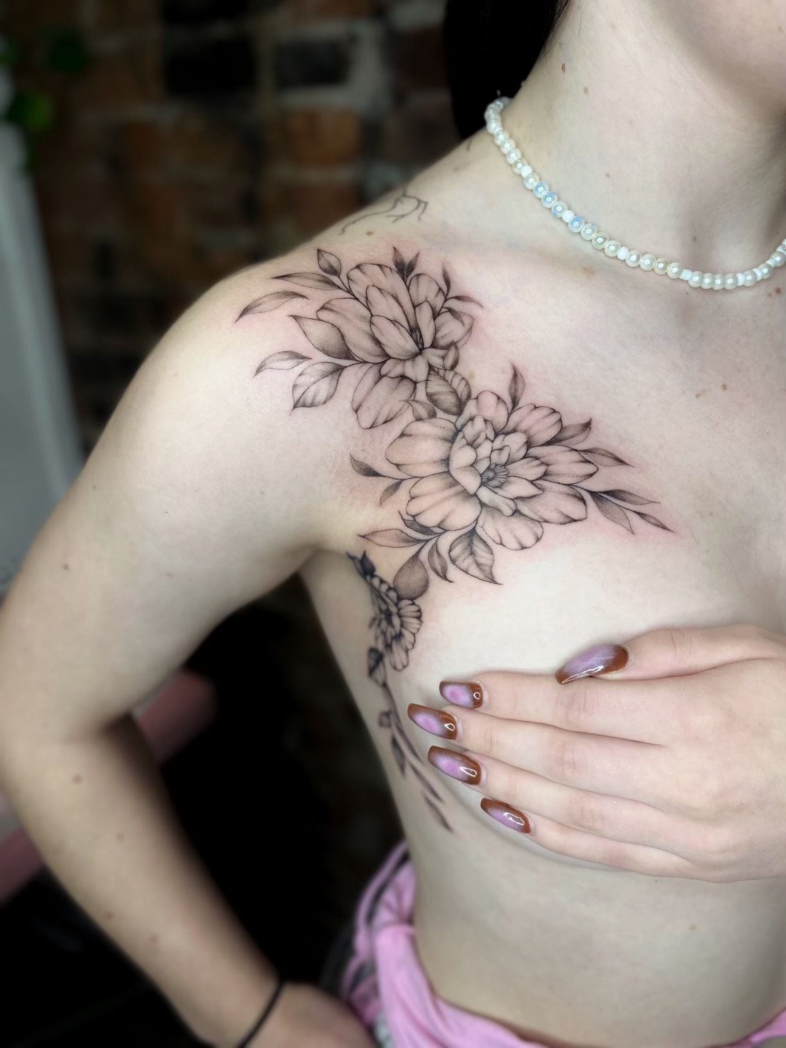 A woman has a tattoo of flowers on her chest