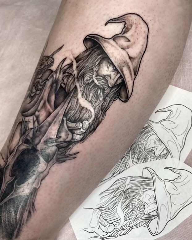 A black and white tattoo of a man with a beard wearing a witch hat.