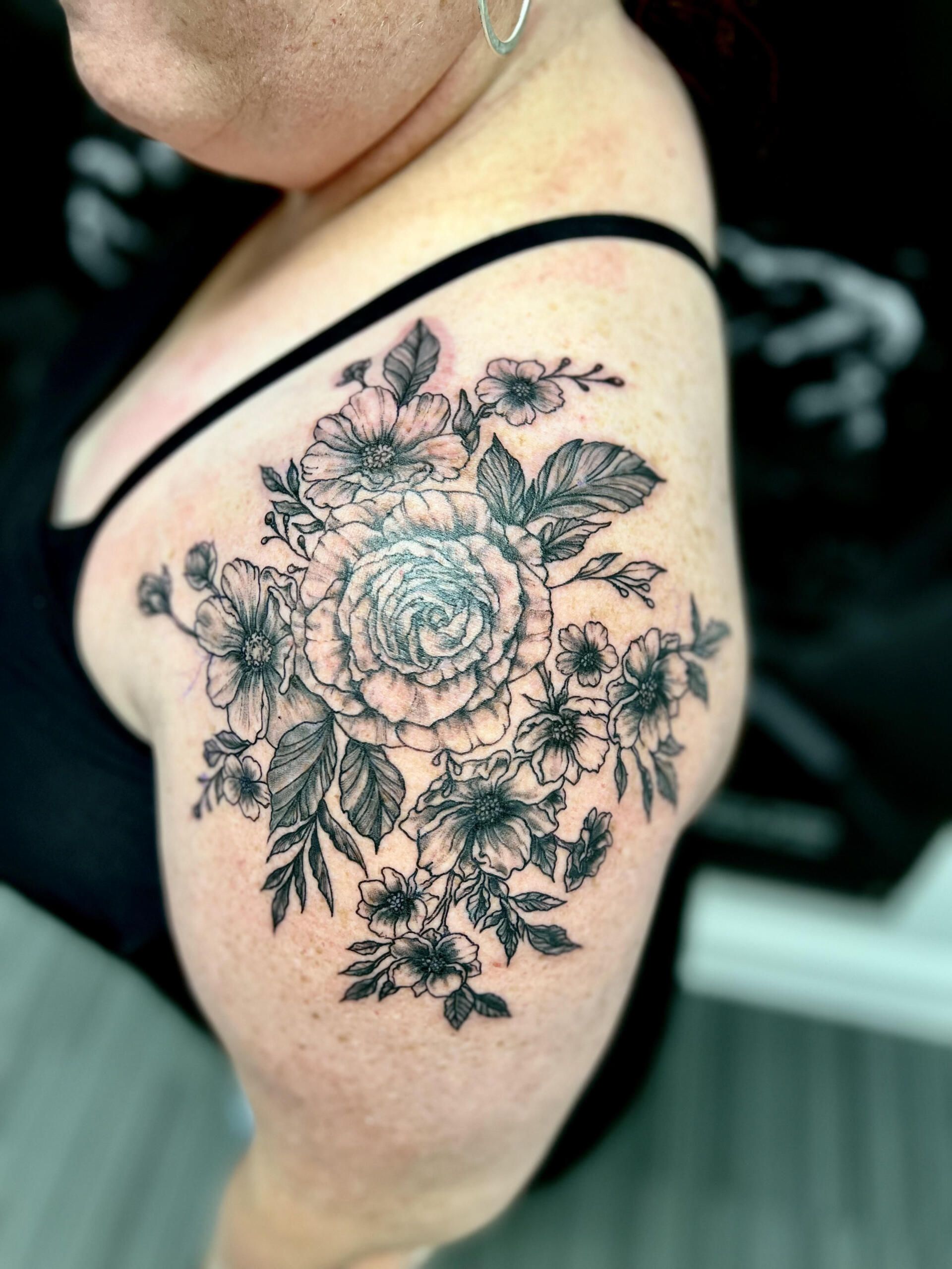 A woman has a tattoo of flowers on her arm