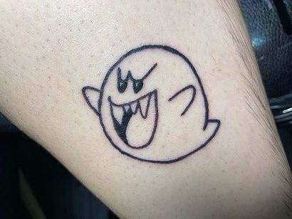 A person has a tattoo of a ghost on their leg.