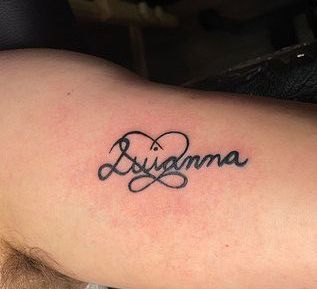 A person has a tattoo of their name on their arm.