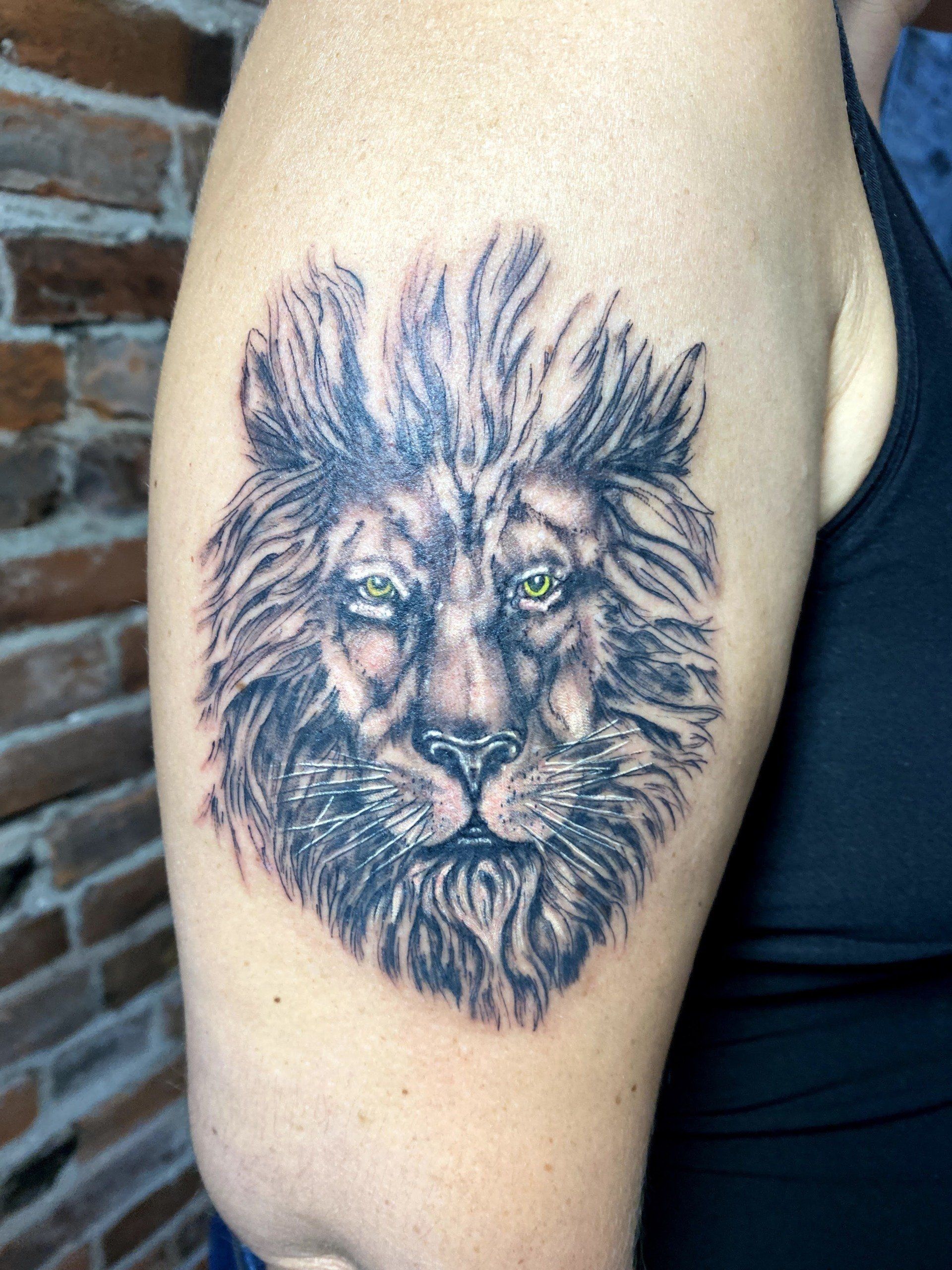 A woman has a tattoo of a lion on her arm