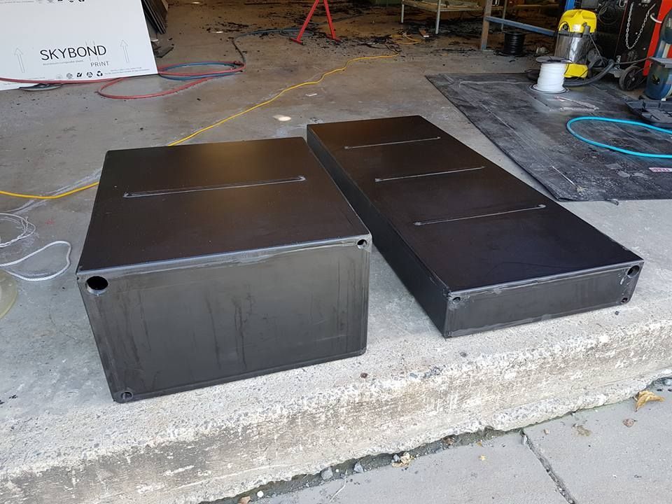 Two Black Boxes Are Sitting on the Sidewalk Next to Each Other — V.I.P. Plastic Fabrication in Portsmith, QLD