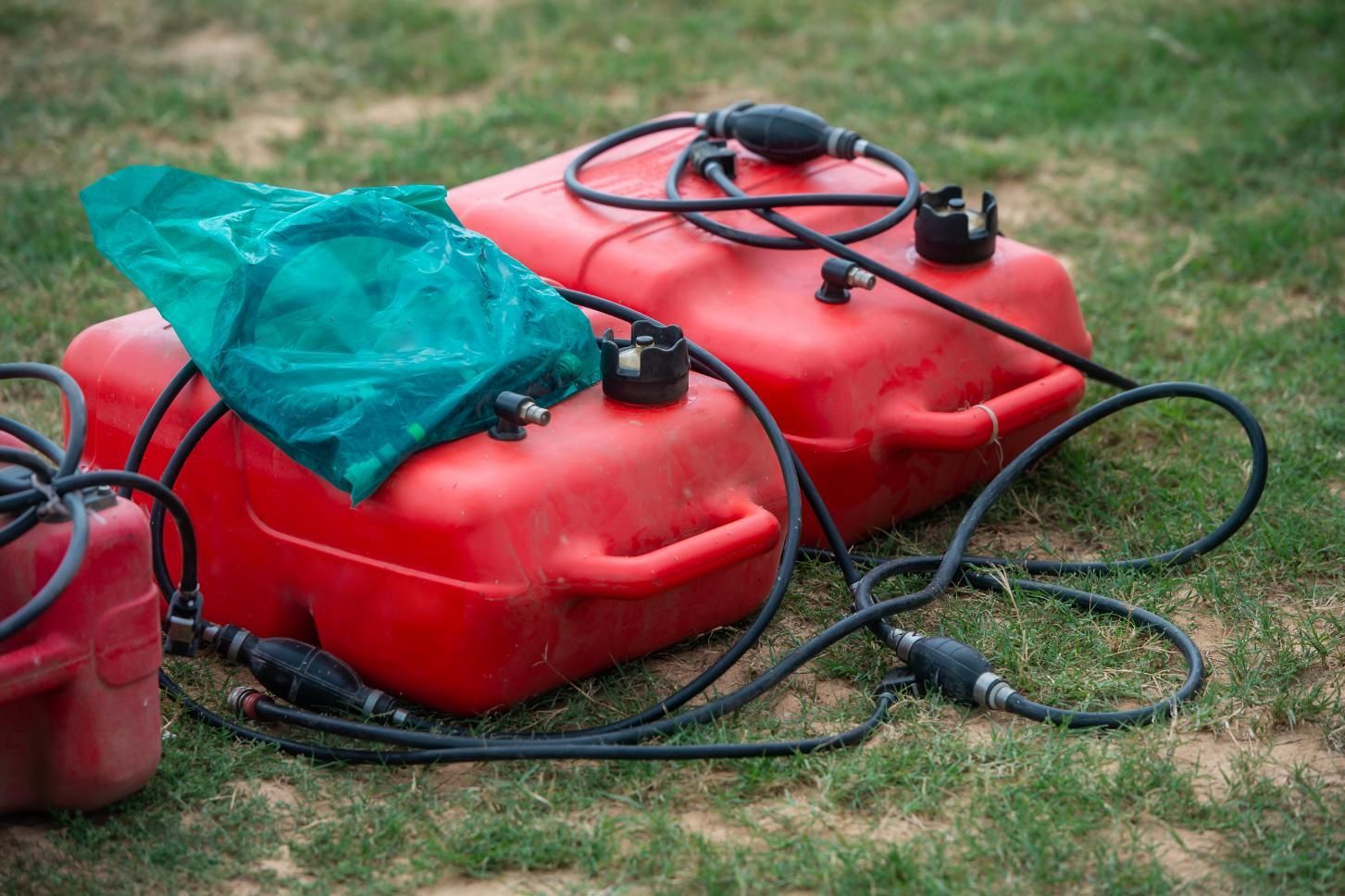 Two Red Gas Cans Are Sitting on Top of Each Other on the Grass — V.I.P. Plastic Fabrication in Cairns, QLD