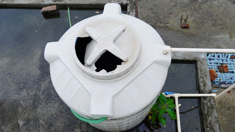 A White Water Tank With a Green Hose Attached to It — V.I.P. Plastic Fabrication in Portsmith, QLD