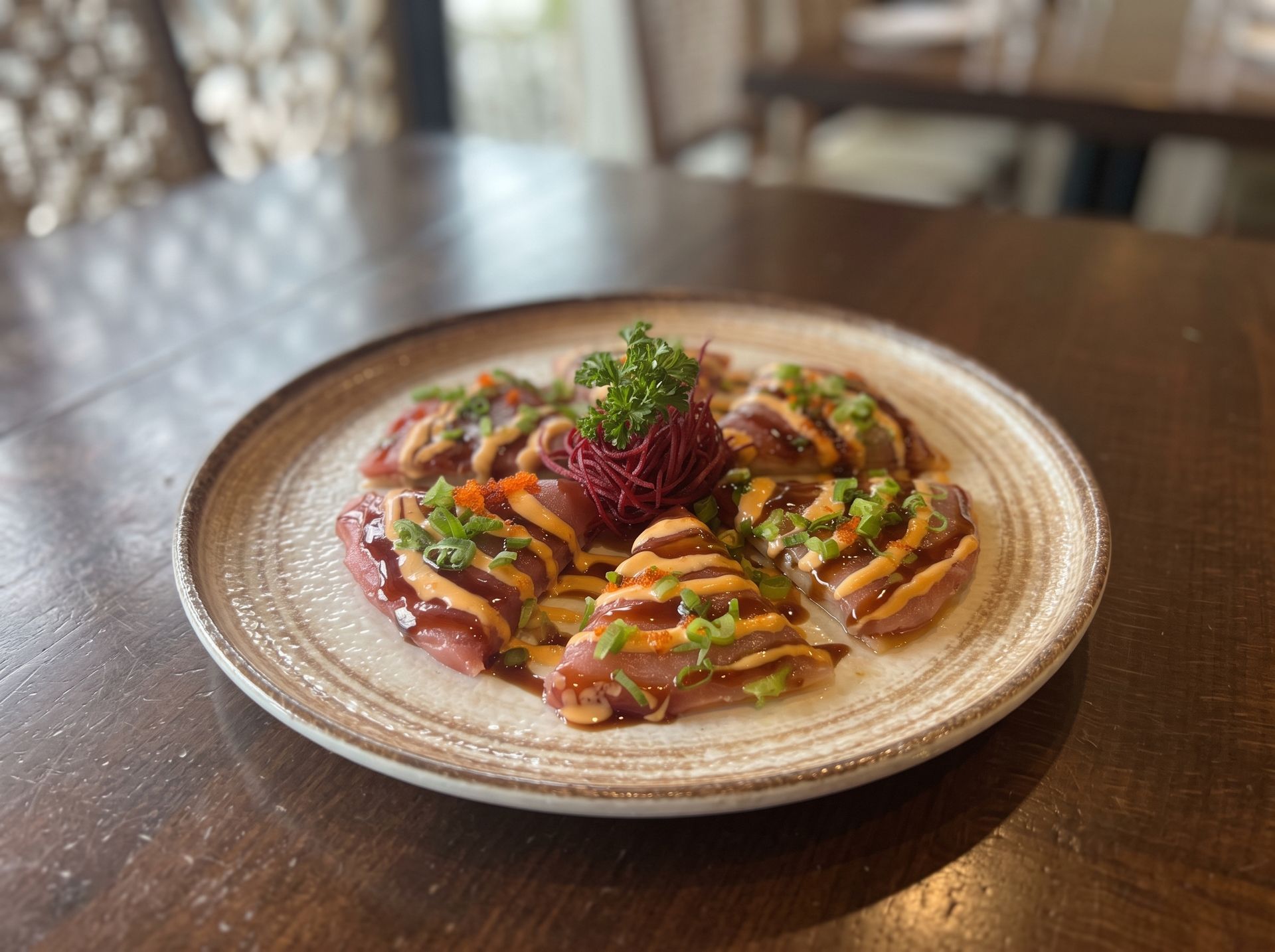 Plated gourmet appetizer with colorful garnishes on a ceramic plate, set on a wooden table