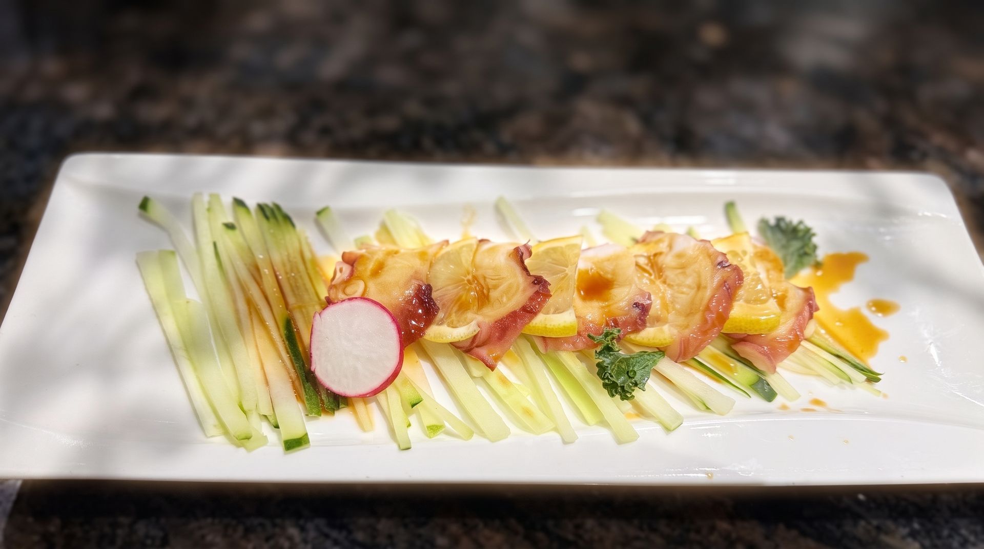 Plated appetizer with avocado strips, radish slices, and garnished shrimp on a white rectangular dish