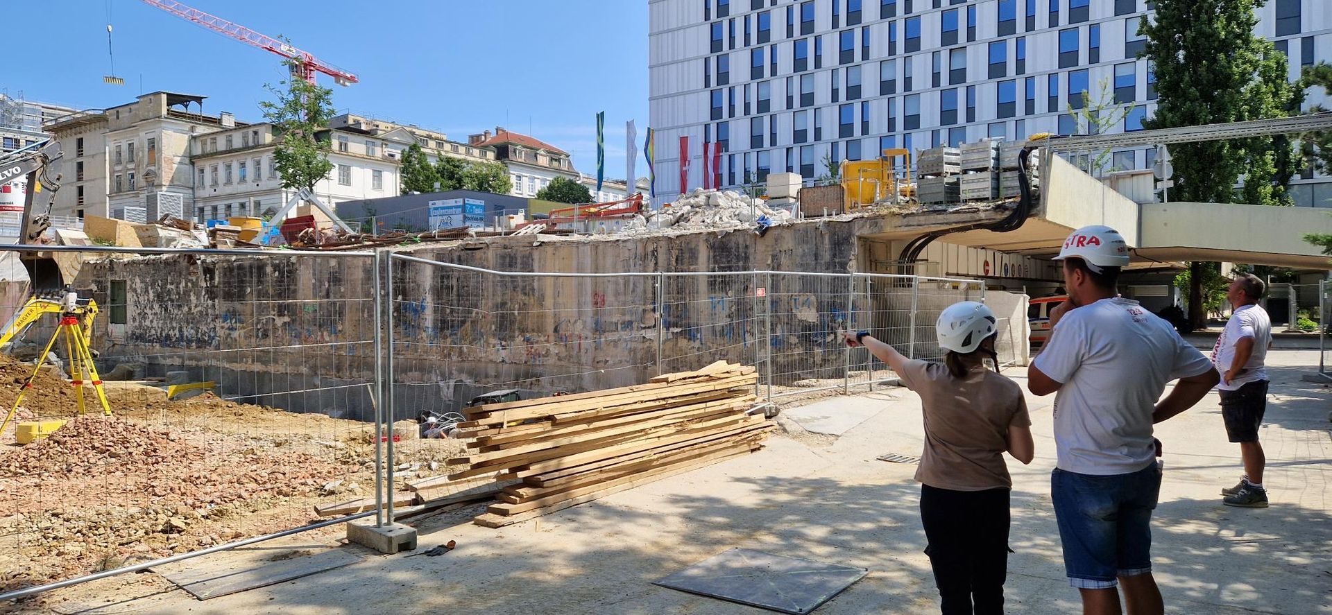 Ein Mann und eine Frau stehen vor einer Baustelle.