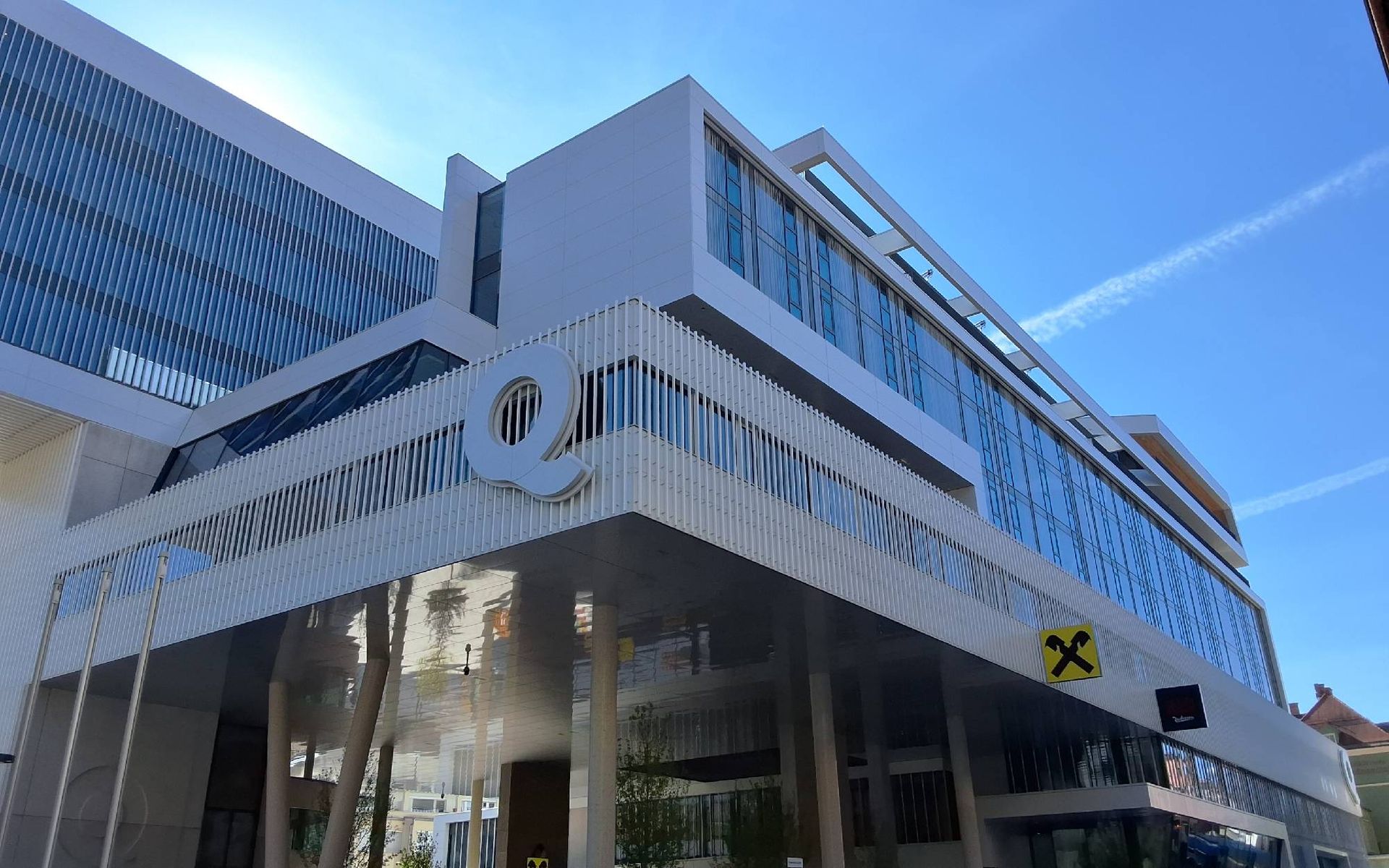 Ein weißes Auto steht vor einem großen Gebäude