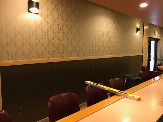 A restaurant with a bar and chairs and a level on the counter.