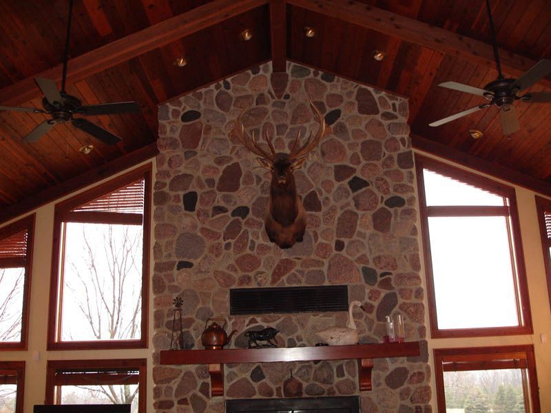A large stone fireplace with a deer head above it