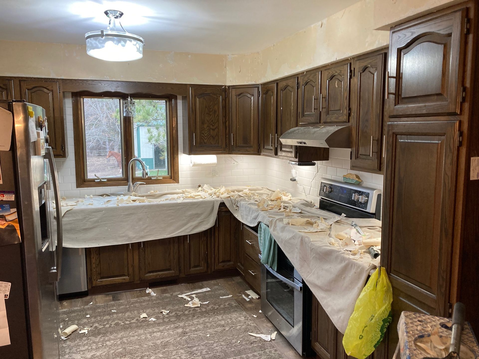 A kitchen with wooden cabinets and stainless steel appliances is being remodeled.