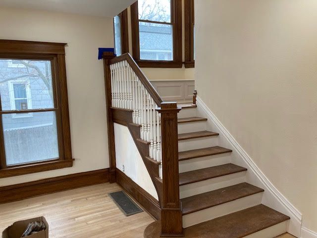A wooden staircase in an empty room with a window