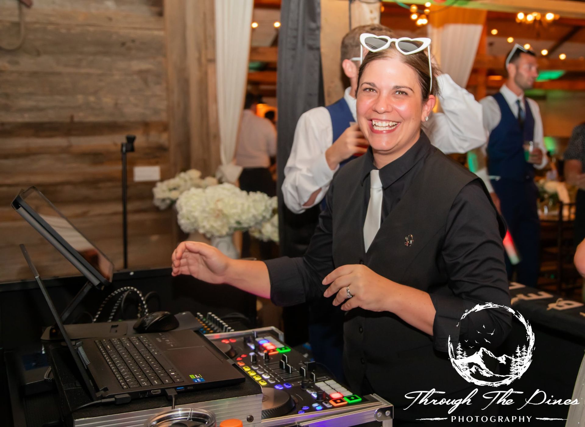 DJ setup with blue lighting, speakers, a photo booth, and geometric shapes.