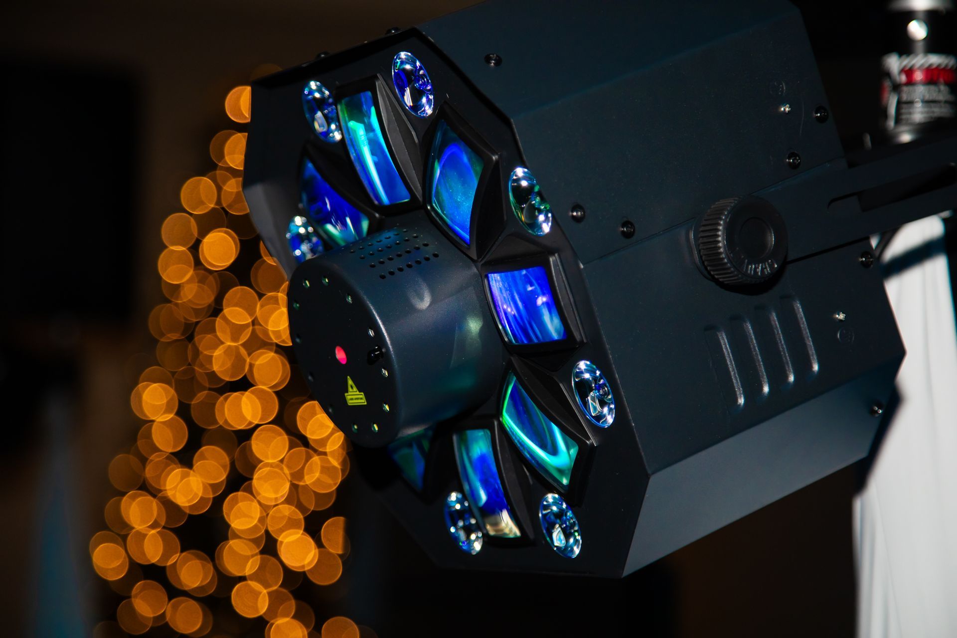 Black stage light with blue and green lenses, bokeh background.