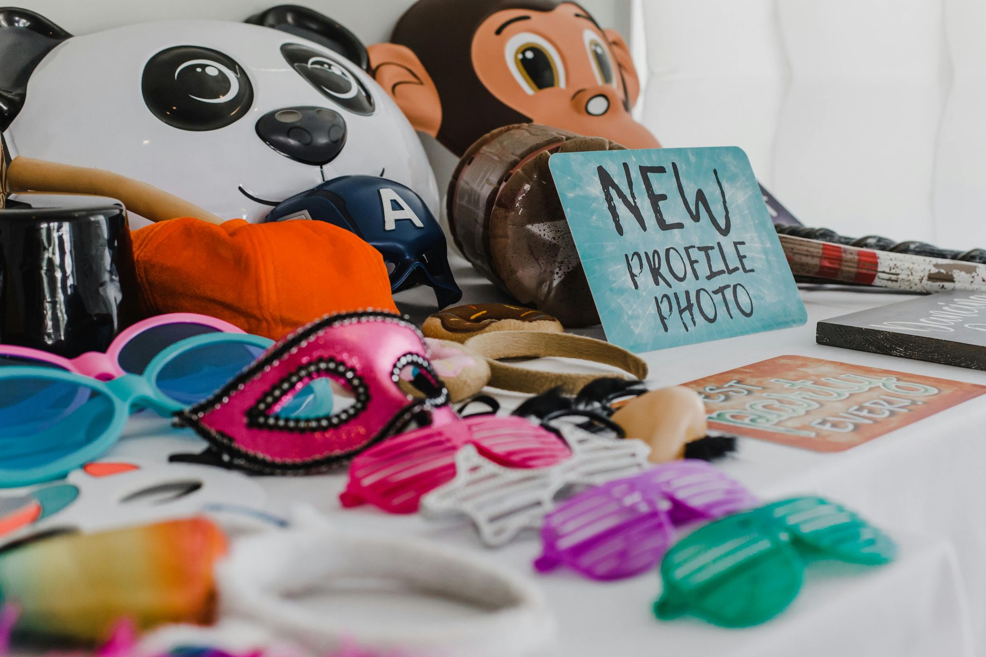Photo booth props: panda and monkey masks, sunglasses, signs that say