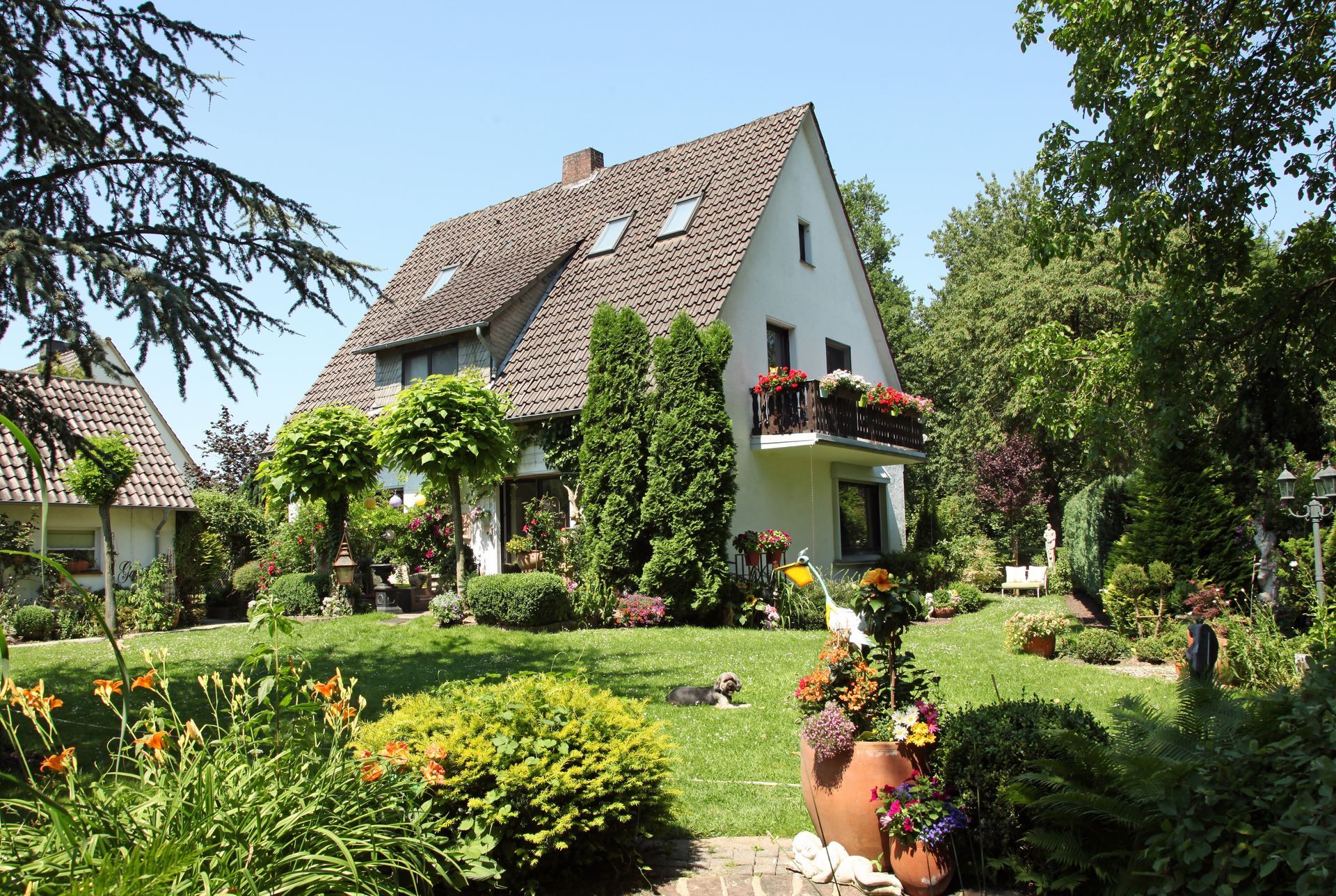 Ein großes Haus ist von einem üppigen grünen Garten umgeben
