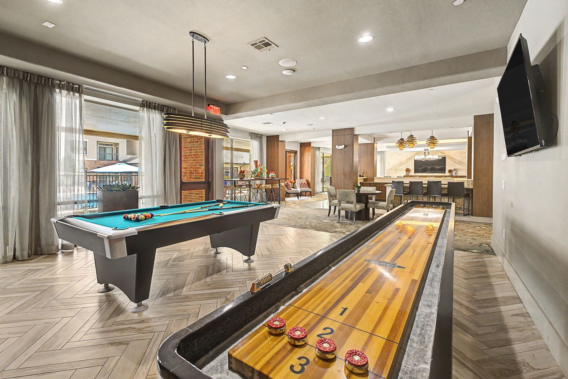 Game room with pool table and shuffleboard in a bright, modern interior at Olympus Sierra Pines at The Woodlands, TX