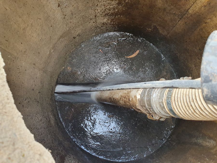 A hose is coming out of a hole in the ground.