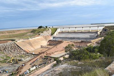 An aerial view of a dam under construction in the middle of a field.