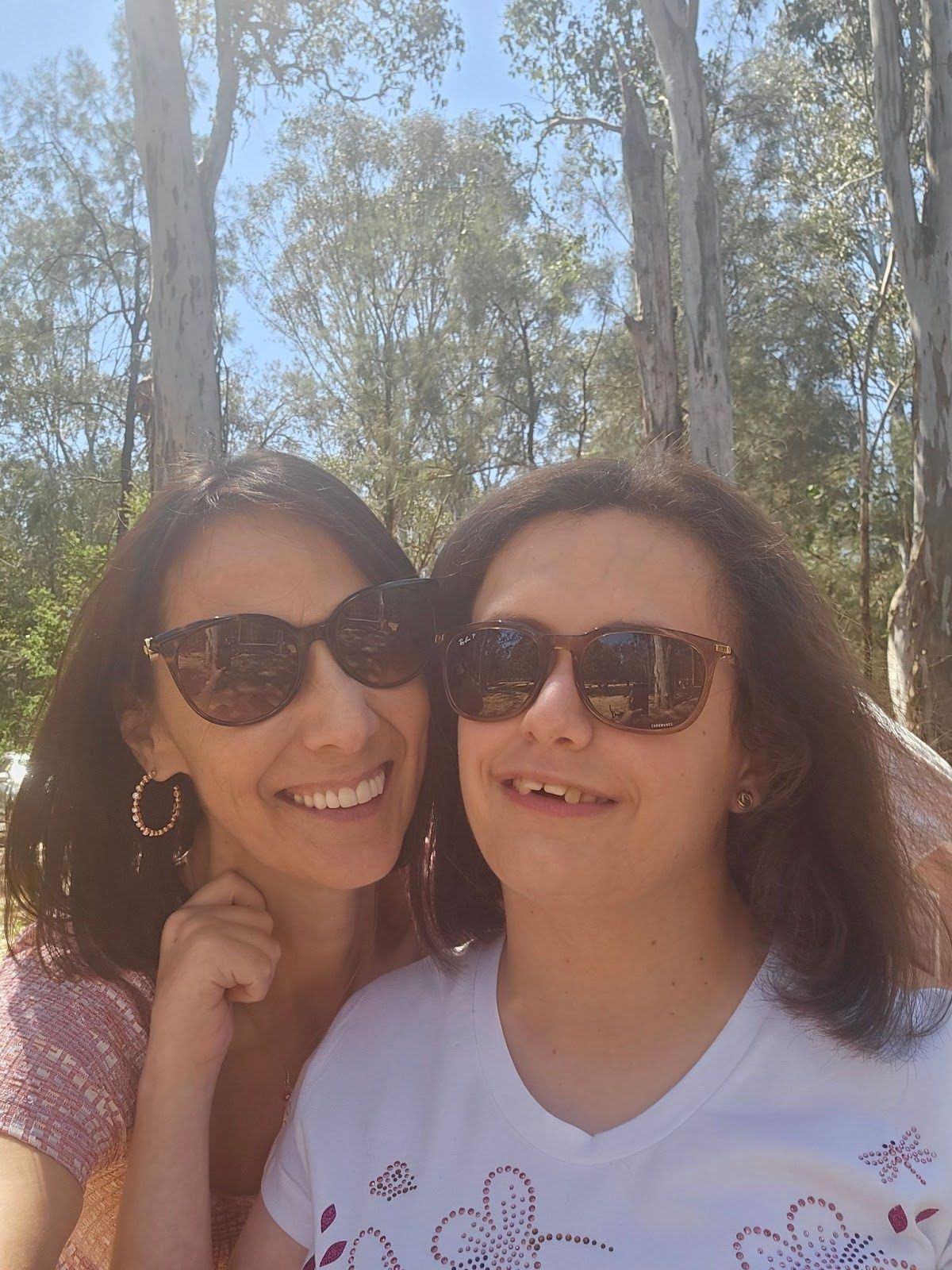 A women are posing for a picture on the beach