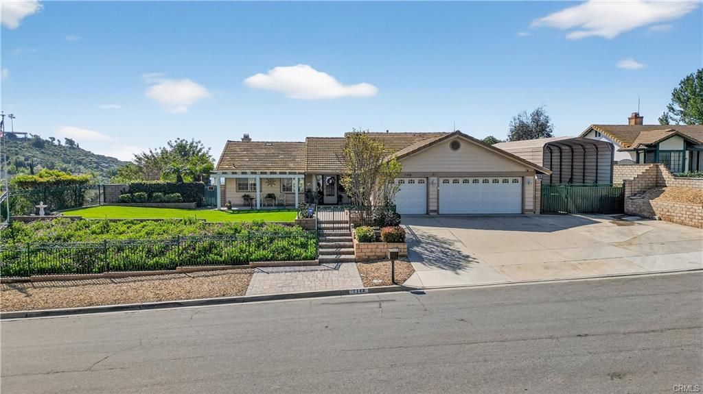 Suburban house with a two-car garage, front lawn, and driveway on a sunny day