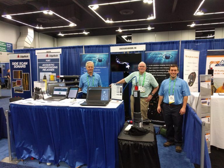 Three men standing in front of a booth that says bob icon