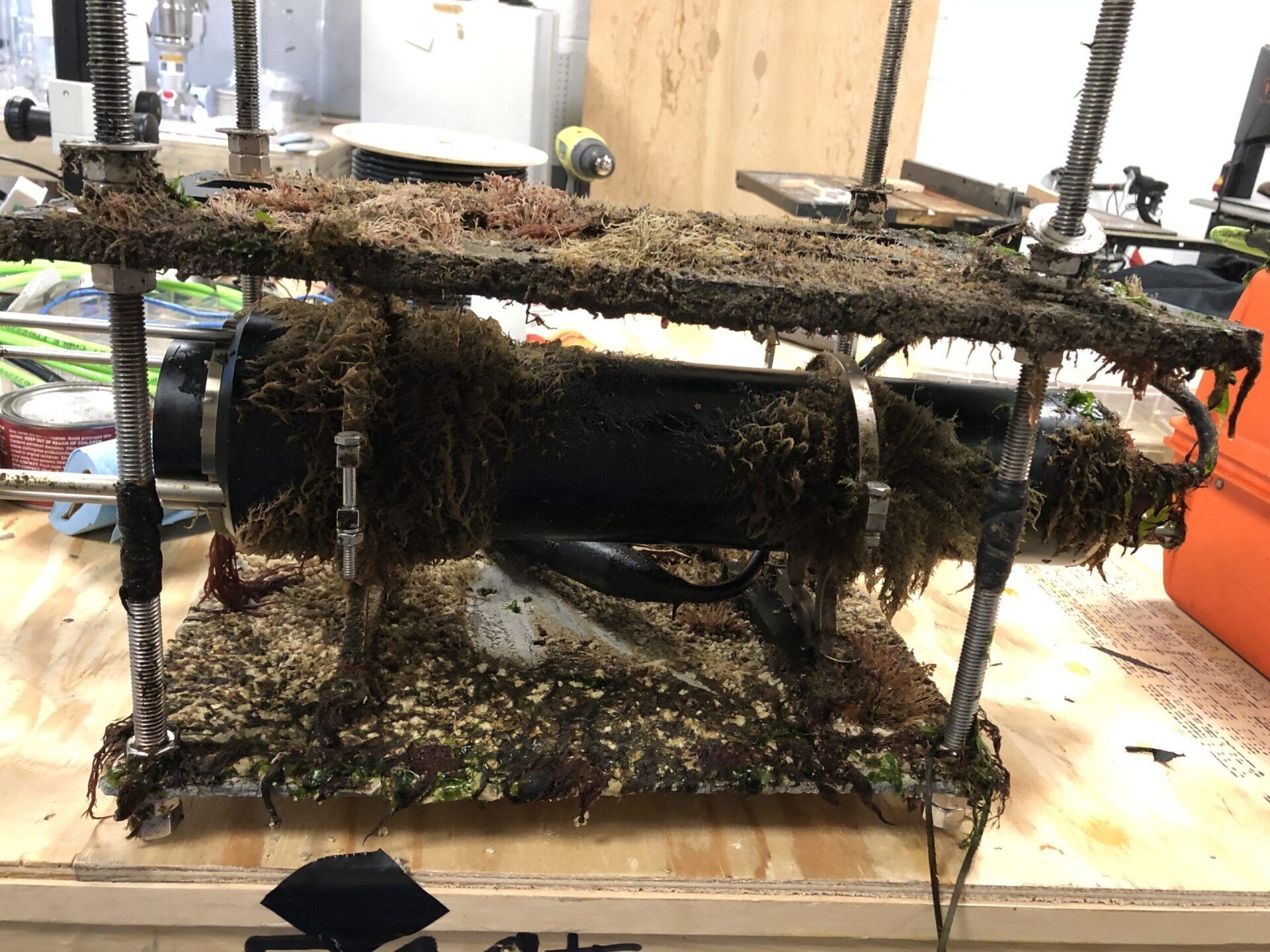 A very dirty piece of equipment is sitting on a wooden table.