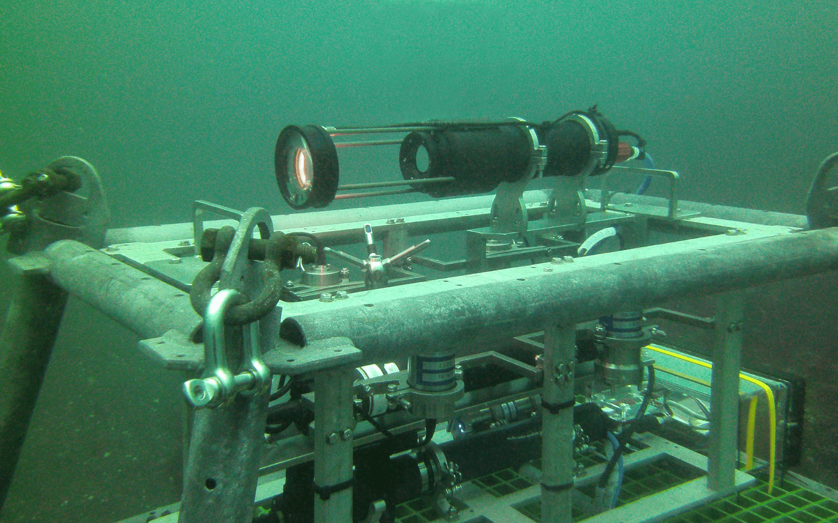 A camera is sitting on top of a metal structure in the water.