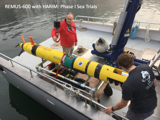 Two men are working on a remus 600 with harum phase 1 sea trials