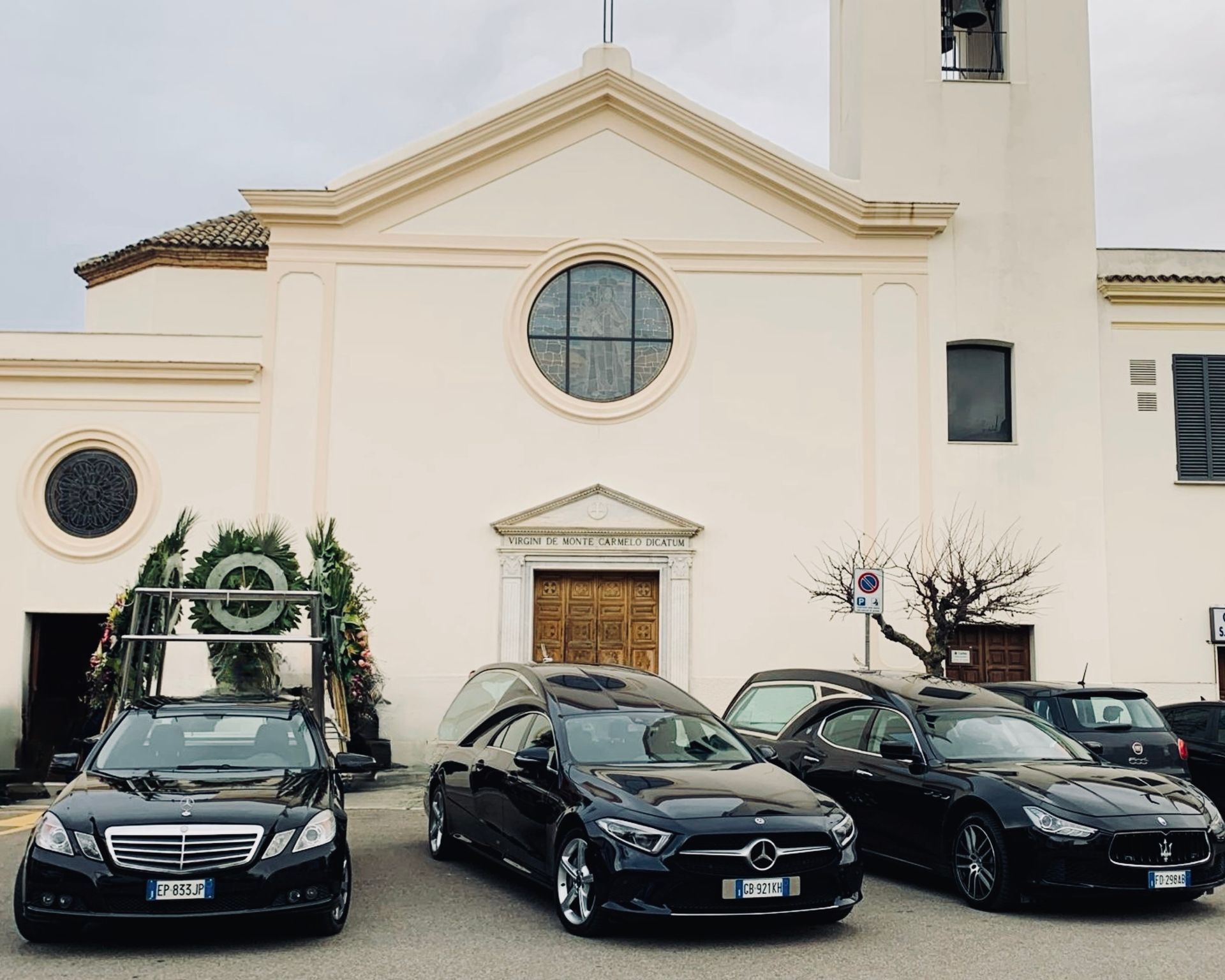Tre auto nere sono parcheggiate davanti a una chiesa