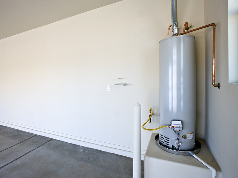 Water Heater Repairs Water heater in a garage, with copper pipes and a vent.