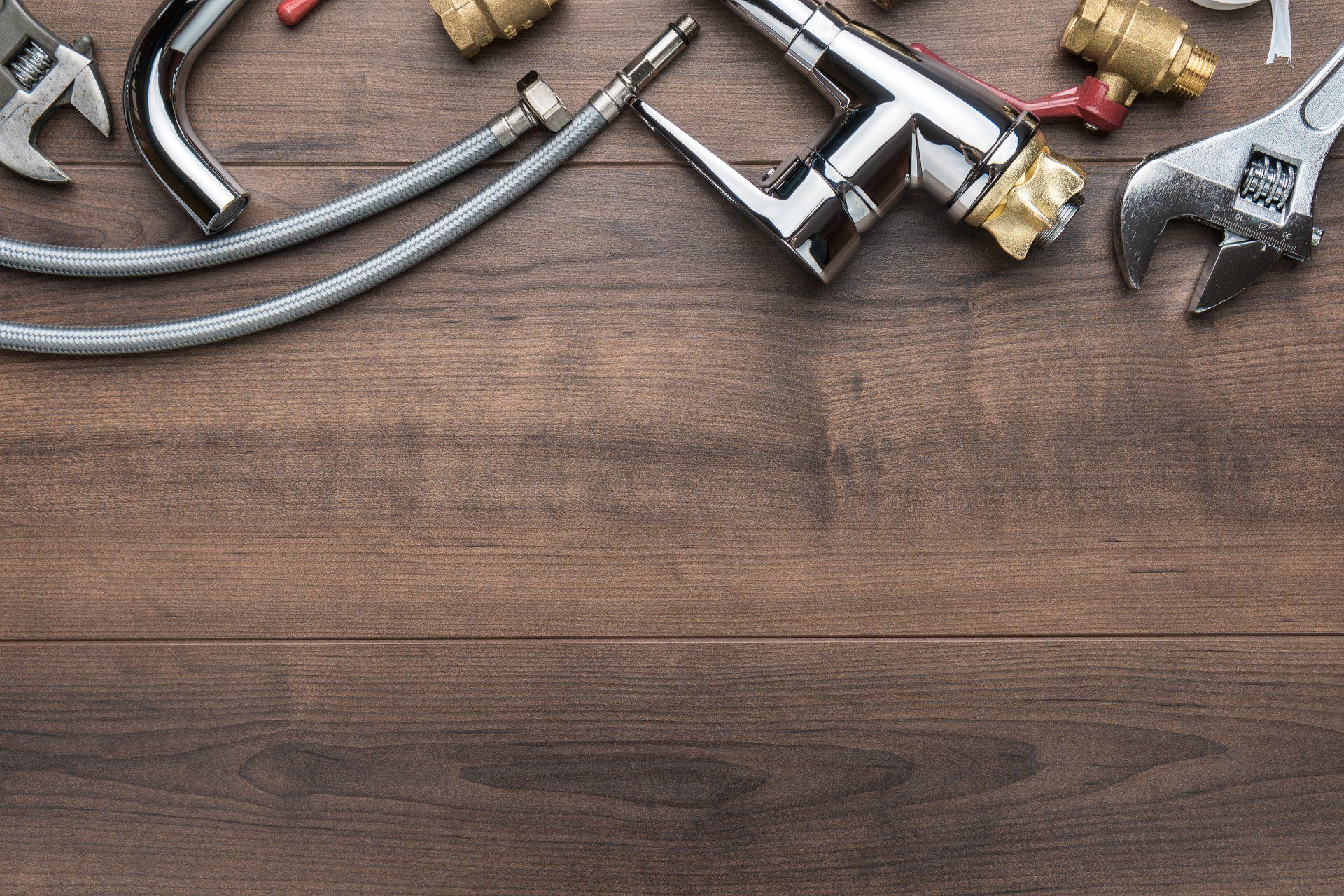 Water Service Line Replacement Plumbing tools and fixtures arranged on a wooden surface.