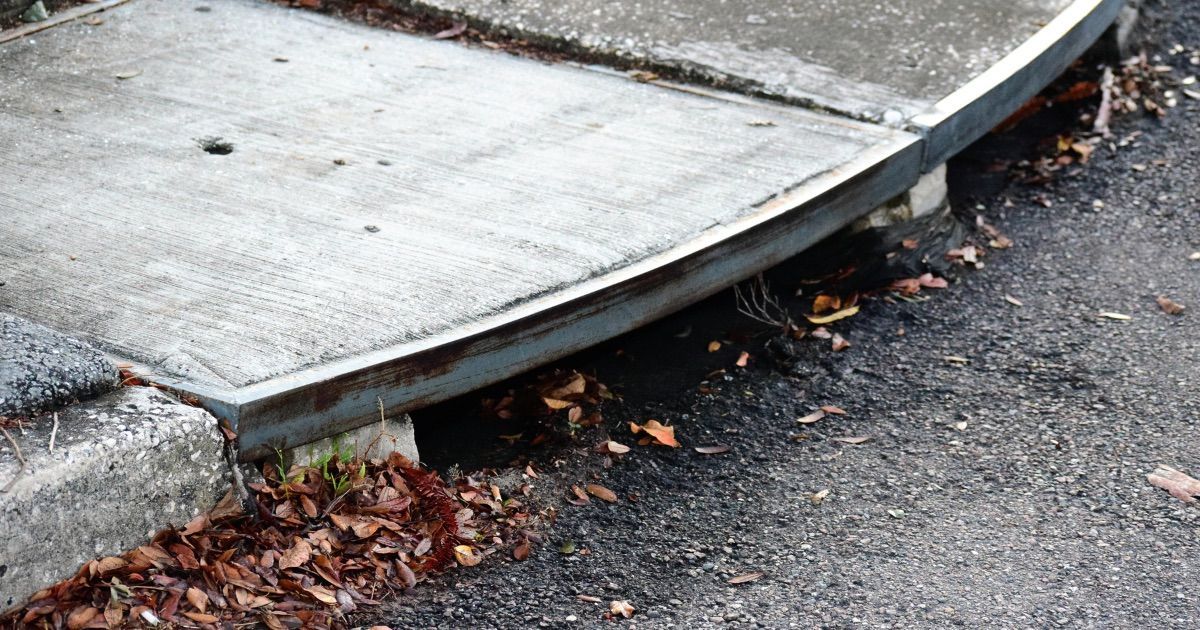 Edge of sidewalk drain with leaves near it
