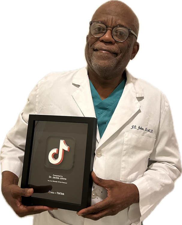 Man in white lab coat holding a TikTok award plaque, smiling at the camera