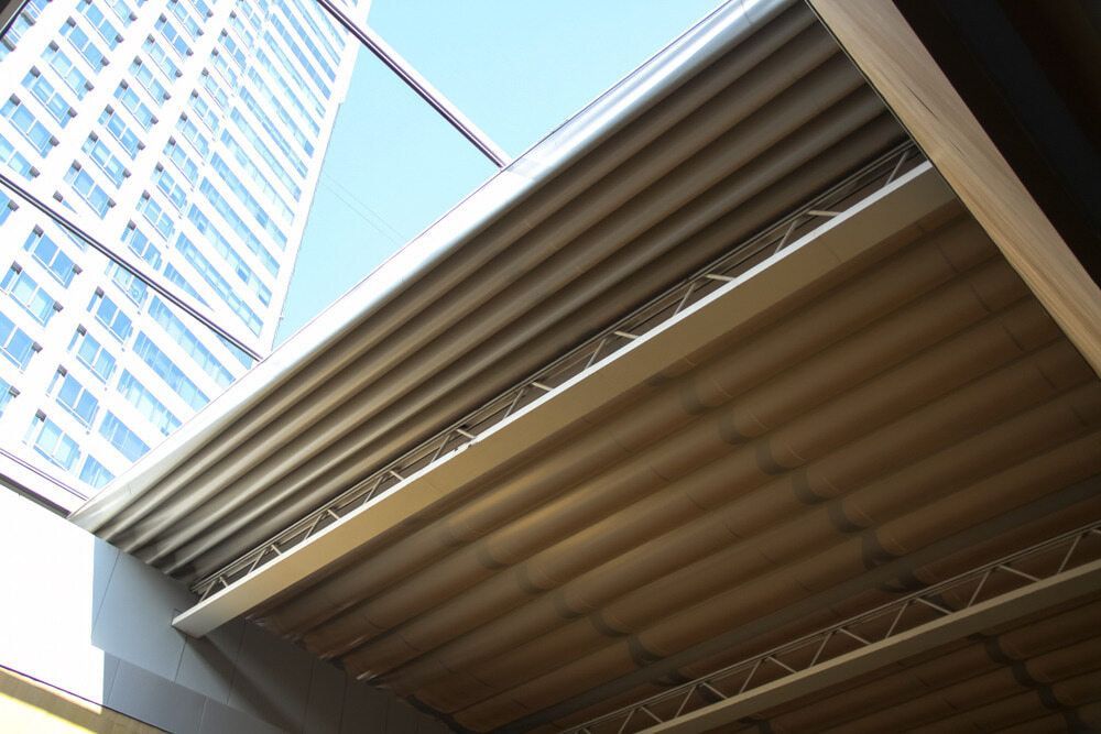 Low-angle View of Corrugated Roof Panels Under a Skyscraper — KNG Roofing And Construction in Katherine, NT
