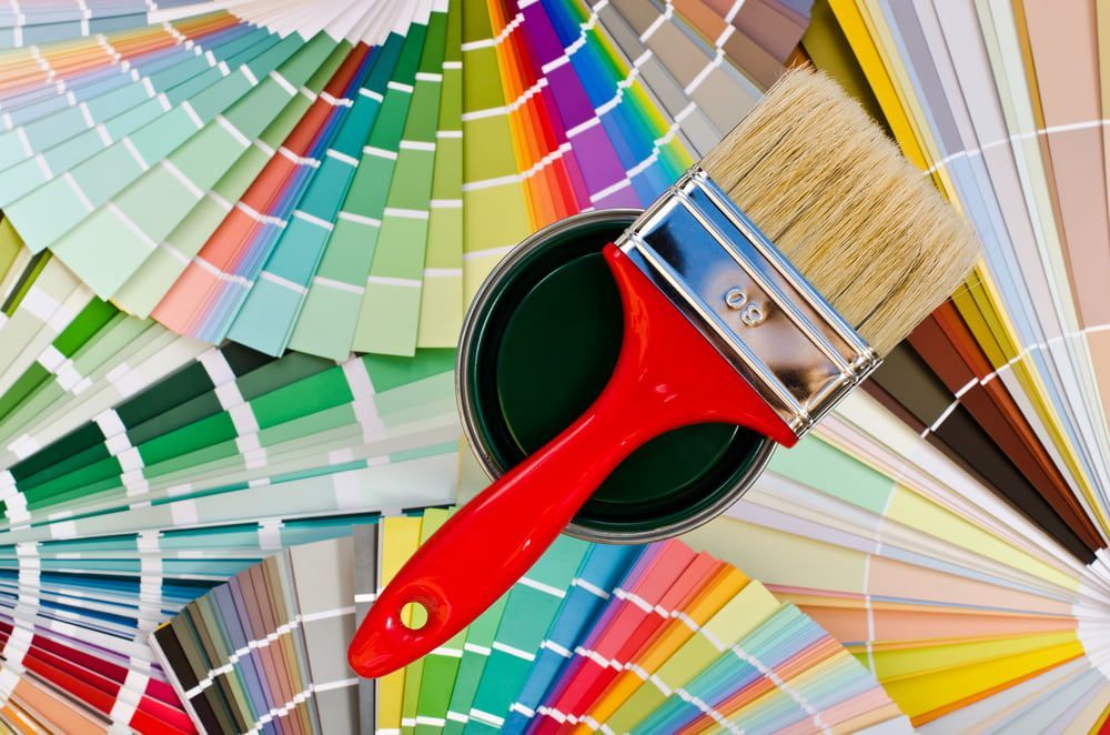Paintbrush on Open Can of Dark Green Paint — KNG Roofing And Construction in Tennant Creek, NT
