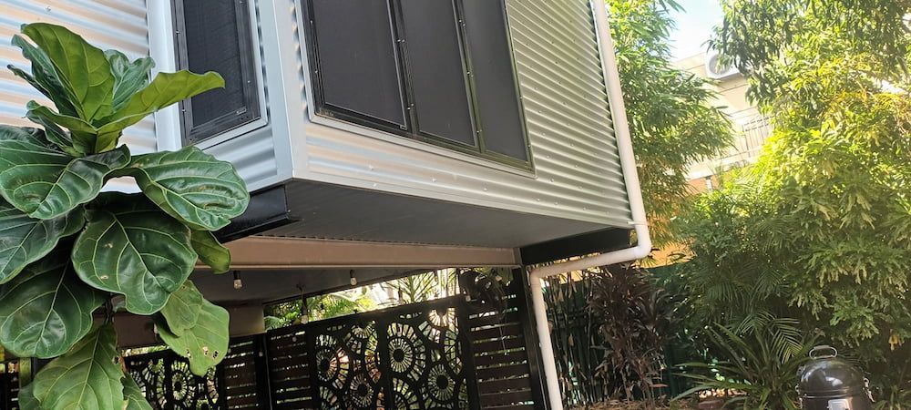 Modern House With Corrugated Metal Siding and Lush Green Foliage — KNG Roofing And Construction in Humpty Doo, NT