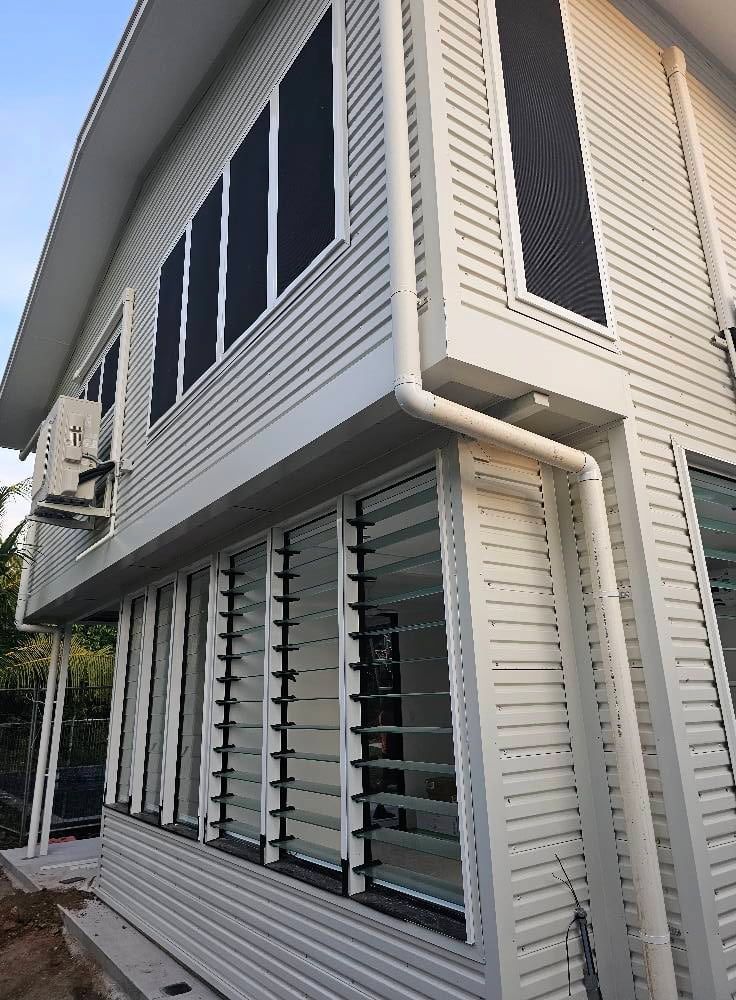 White House With Louvred Windows and Air Conditioning Unit — KNG Roofing And Construction in Darwin, NT