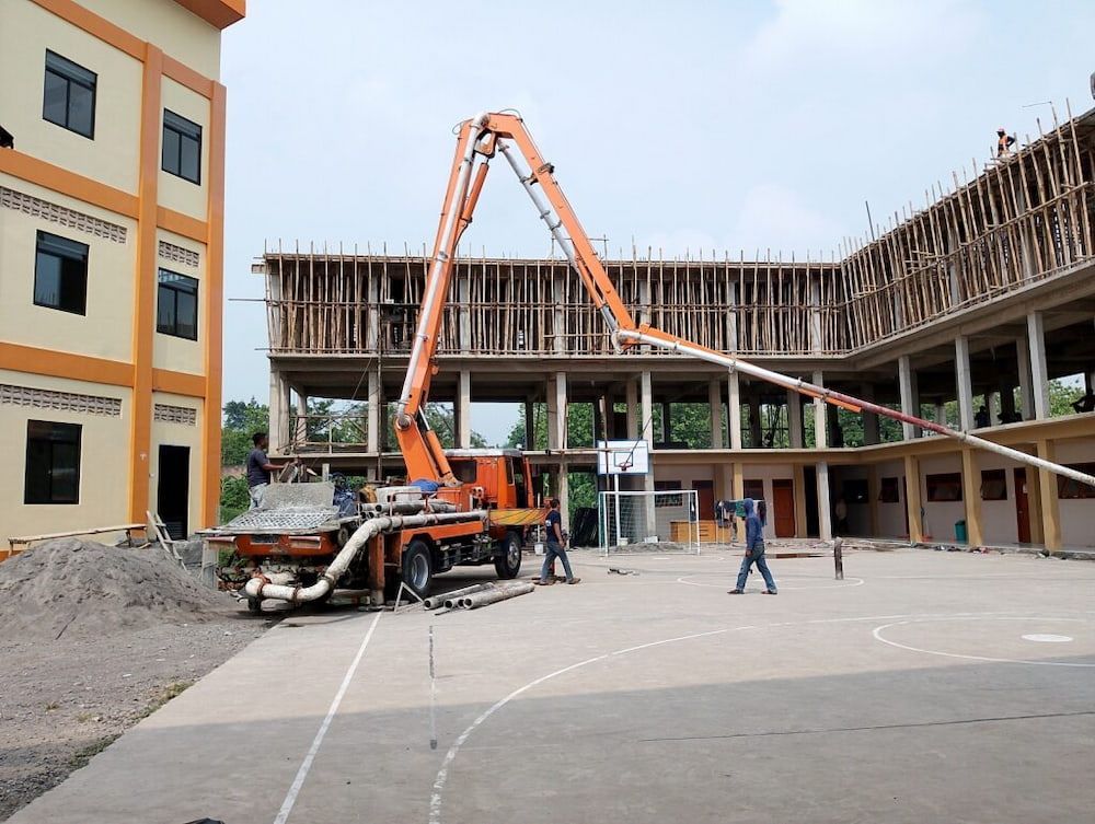 Men Working, Buildings in the Background — KNG Roofing And Construction in Darwin, NT
