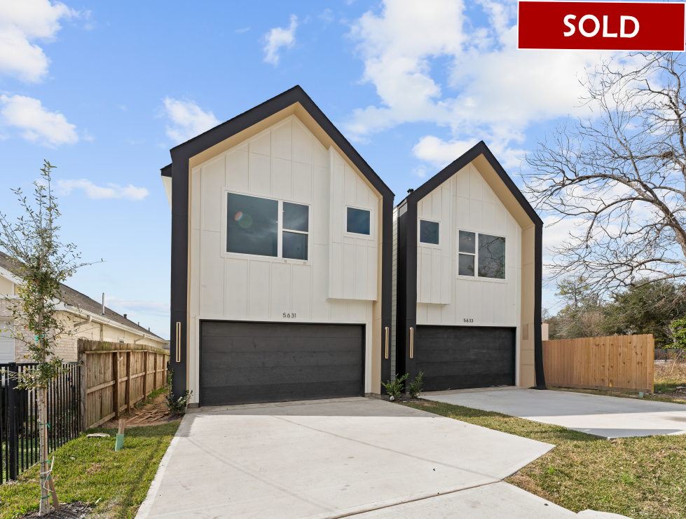 Two modern white houses with black trim and garage doors, 
