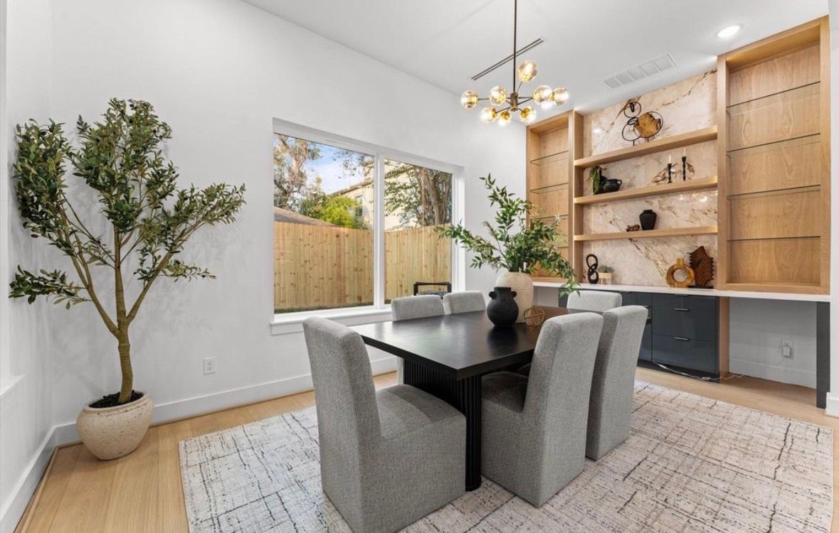 Dining space with wood shelving accent wall and natural light in modern transitional home