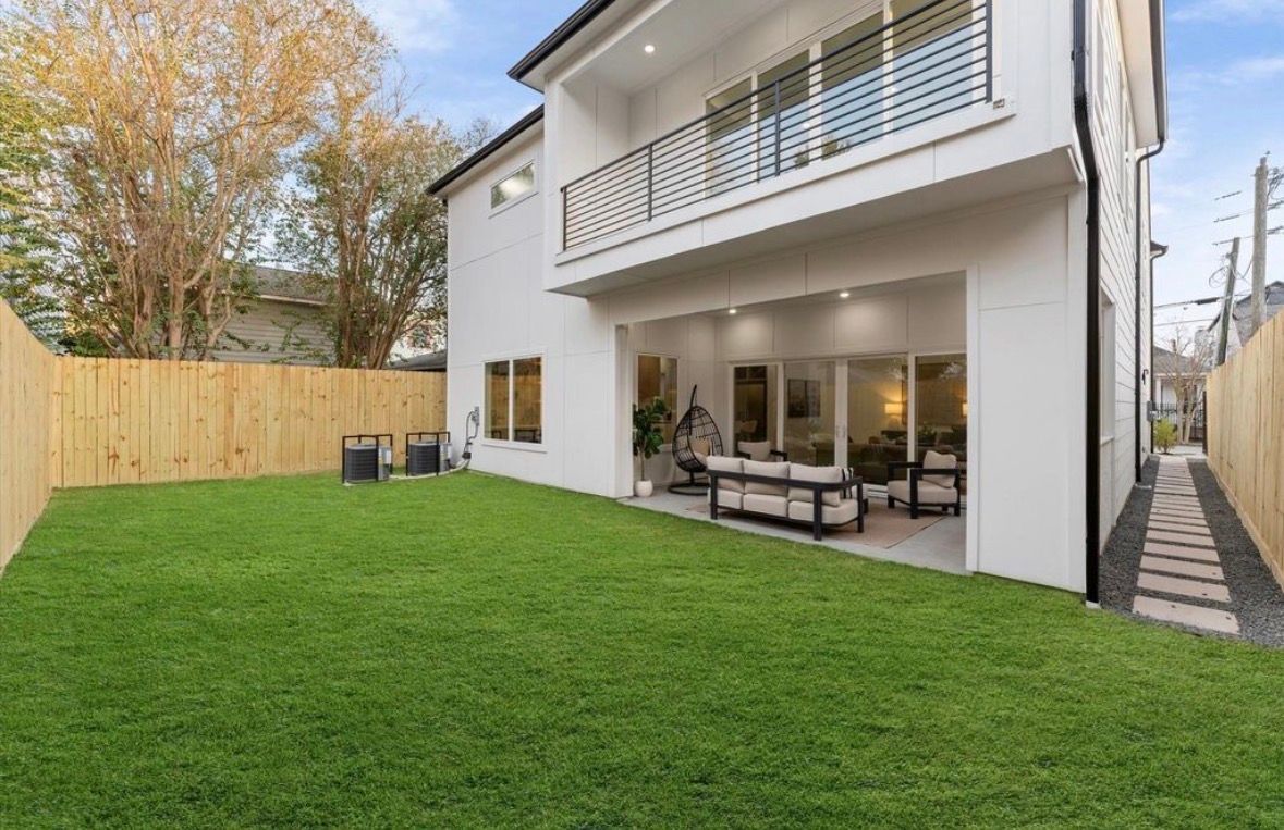Private backyard with covered patio and green lawn at Montrose luxury home