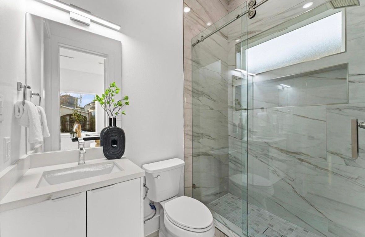 Walk in glass shower with tile walls and modern fixtures in Houston home