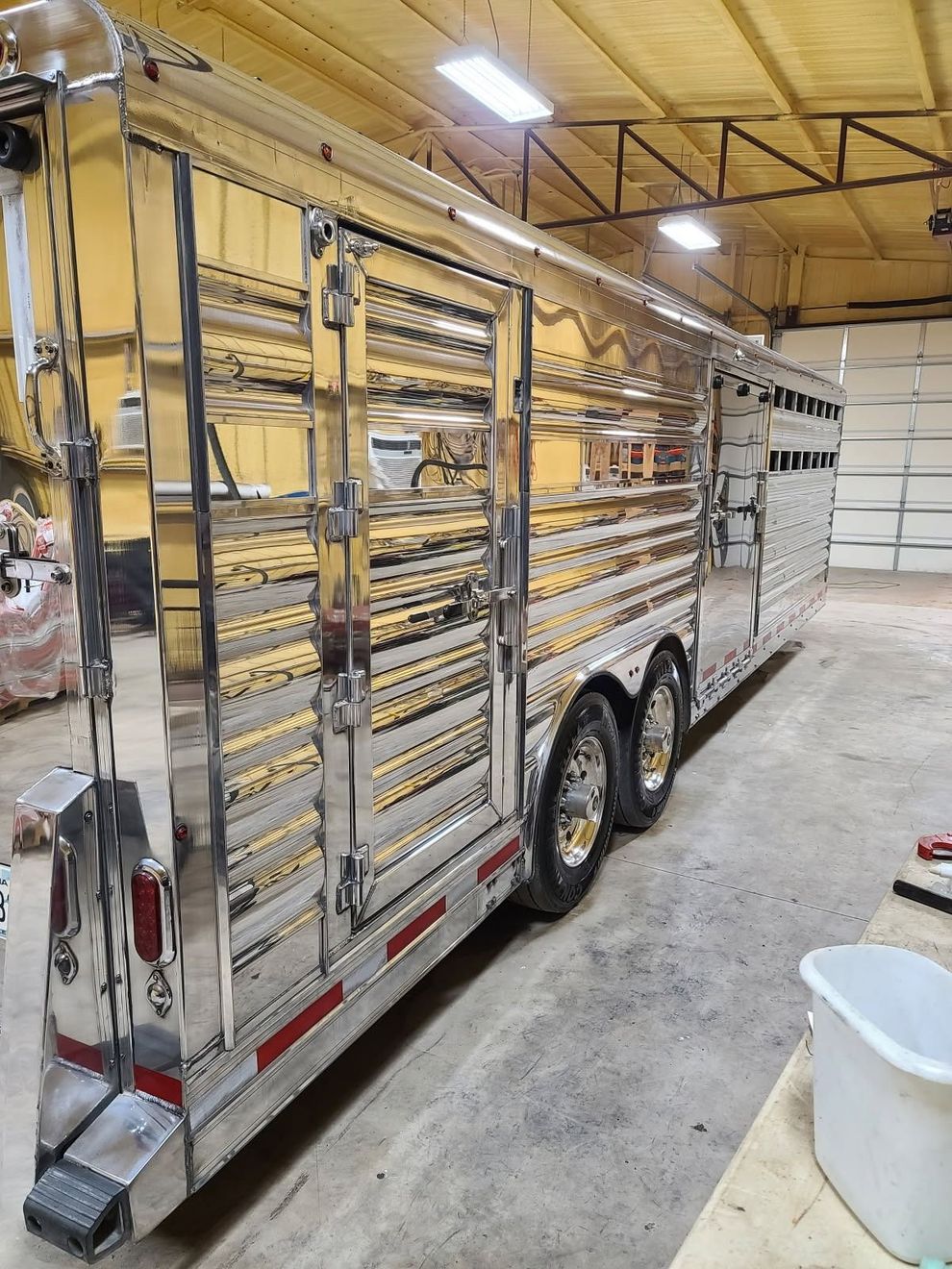 Shiny silver stock trailer in an indoor setting.