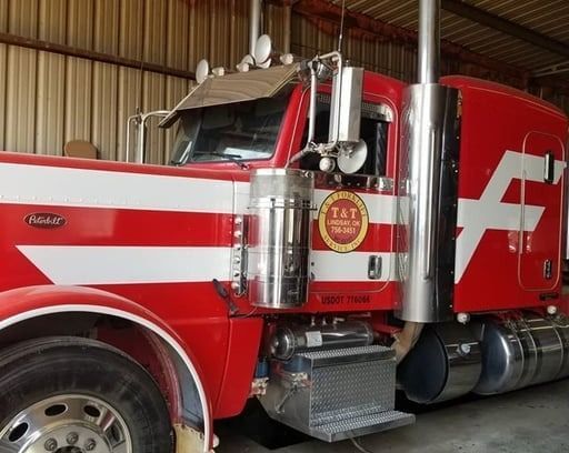 Red and white Peterbilt semi-truck with chrome accents and the 