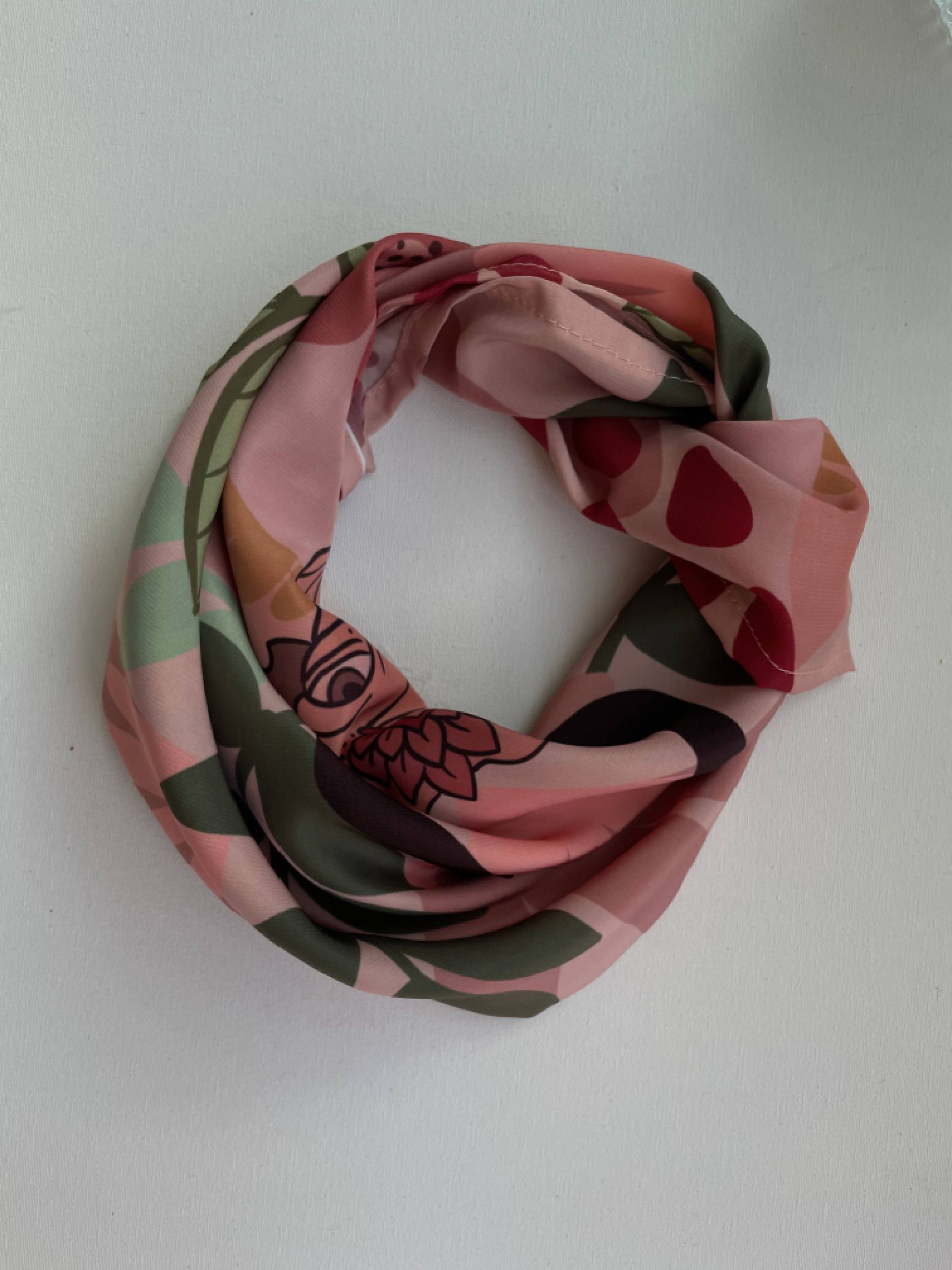 Bufanda estampada en forma circular de color rosa y verde.