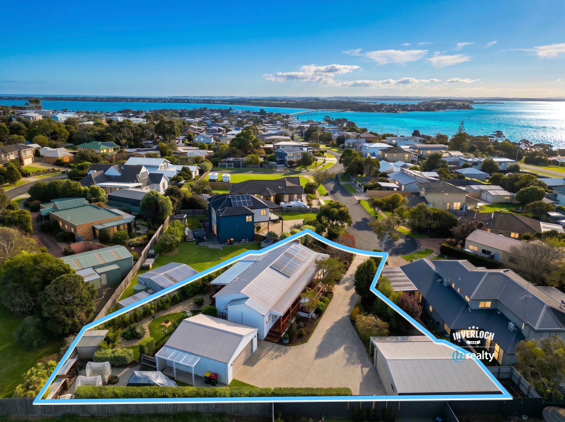 Aerial view of a coastal neighborhood with a highlighted property near the water.