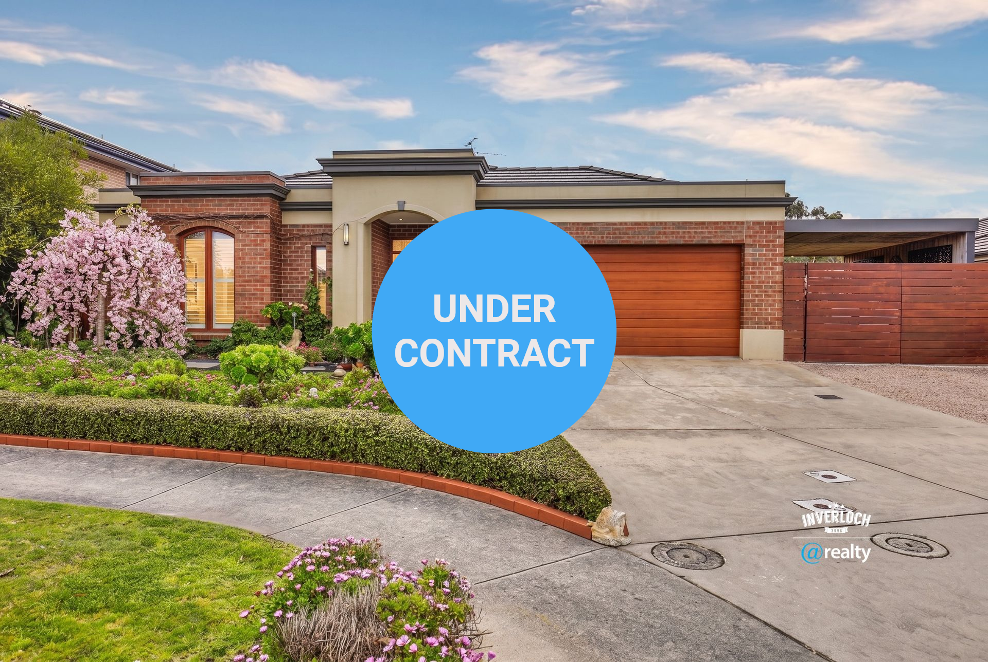 Modern single-story brick house with a wooden garage door, landscaped front yard, and driveway